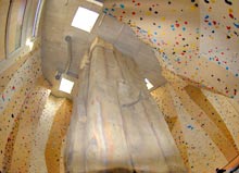 Kletterhalle mit einer felsartigen Kletterwand in der Mitte