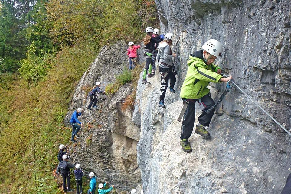 Kinder beim Klettern an einem Klettersteig in Muotathal