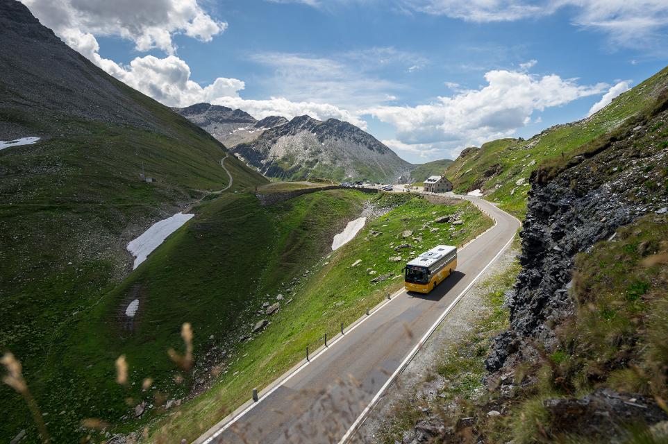 Postauto auf dem Weg über einen Alpenpass in der Ferienregion Andermatt