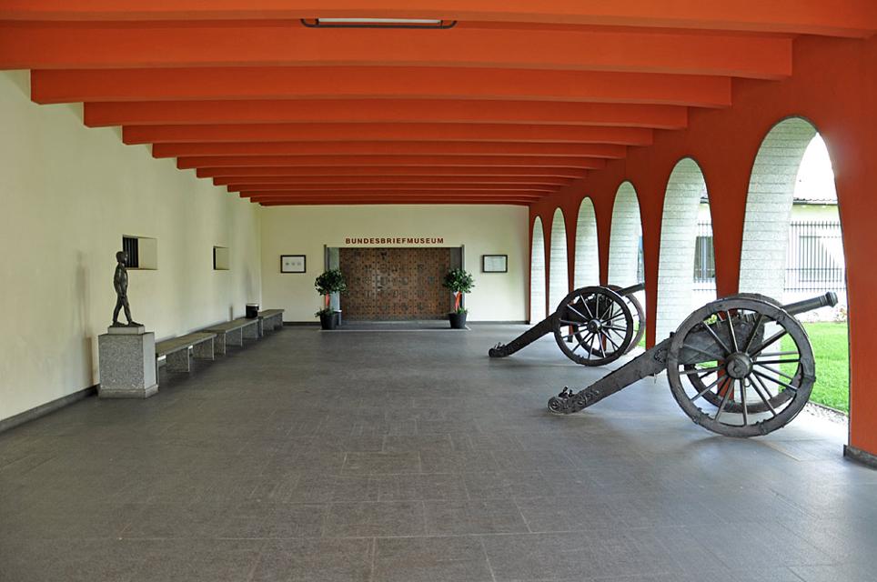 Von Kanonen gesäumter Arkadengang zum Eingang des Bundesbriefmuseums in Schwyz