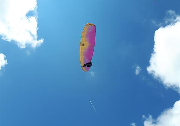 Paragleiter über der Alm