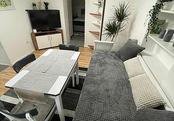 Wohnzimmer mit TV und SItzgruppe