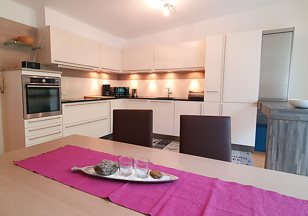 komplett ausgestattete Küche mit großem Esstisch