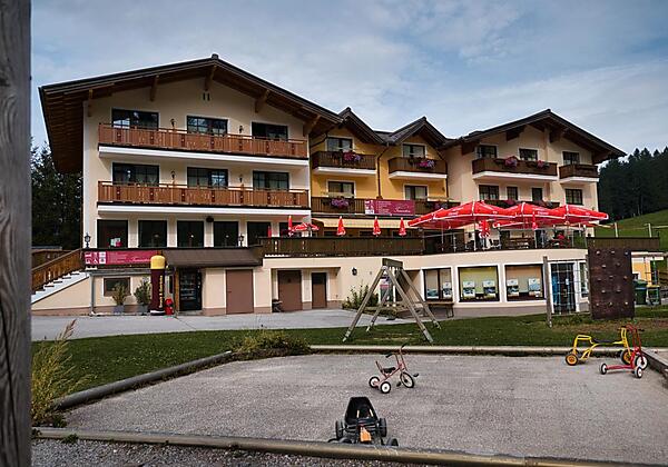 Hausansicht Sommer mit Spielplatz